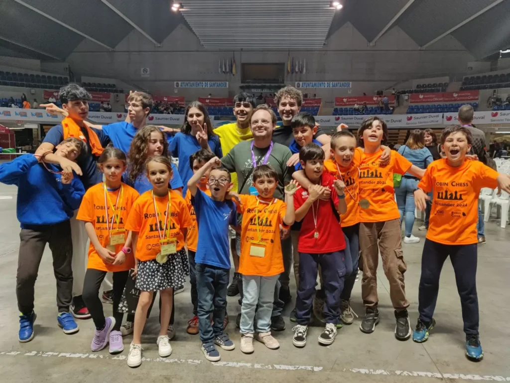 Grupo de jóvenes del club participando en un torneo de ajedrez en un pabellón