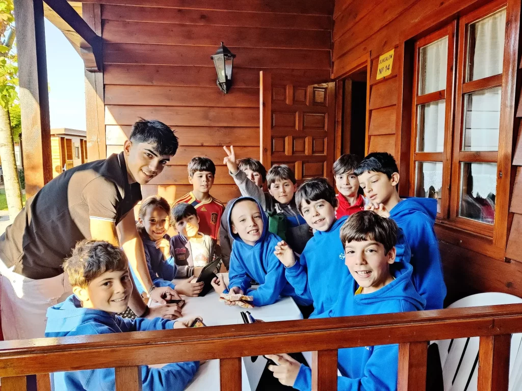 Niños del club reunidos en una actividad en una casa de madera