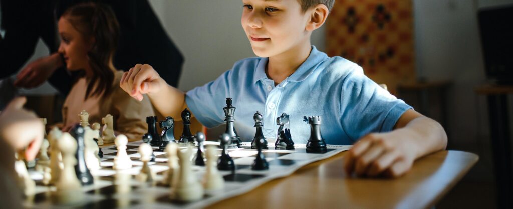 Niño realizando una jugada durante una partida de ajedrez
